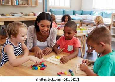 Teacher And Pupils Using Wooden Shapes In Montessori School - Shutterstock ID 641754271