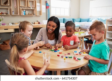 Teacher And Pupils Using Wooden Shapes In Montessori School - Shutterstock ID 641754307