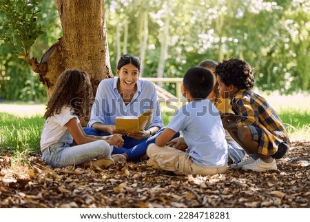 Teacher reading, tree or children with book for learning development, storytelling or growth in park. Smile, youth or happy educator with stories for education at a kids kindergarten school in nature Foto stock © 