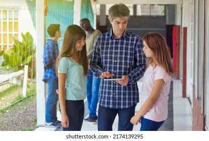 Teacher In The School Hallway Talking To His Multi Ethnic Classroom.