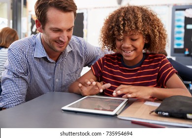 Teacher and schoolboy using tablet computer in class - Powered by Shutterstock