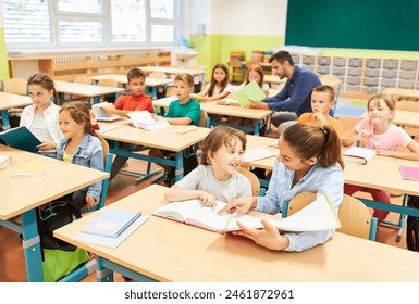 Teacher and schoolgirl having fun while studying in classroom - Powered by Shutterstock