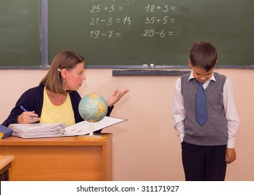 The teacher scolds a little schoolboy in a classroom. - Powered by Shutterstock