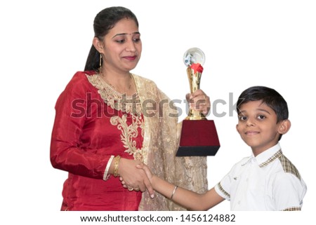 Teacher shaking hands and awarding winner trophy to student
