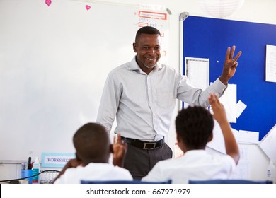 Teacher showing hand in front of an elementary school class