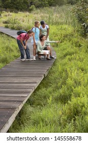 Teacher Showing Something To Children On Nature Field Trip