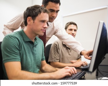 Teacher Showing Something On Screen To Mature Students In The Computer Room