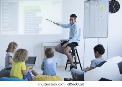 Teacher Shows Students How To Program On An Interactive Whiteboard. Modern Teaching Concept