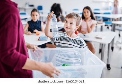 A teacher with small school kids in classroom learning about waste separation. - Powered by Shutterstock