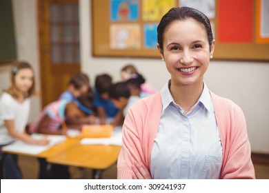 Teacher smiling at camera in classroom at the elementary school