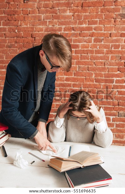 Teacher Standing Desk Behind Tired Student Royalty Free Stock Image