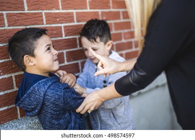 A Teacher Stopping Two Boys Fighting In Playground