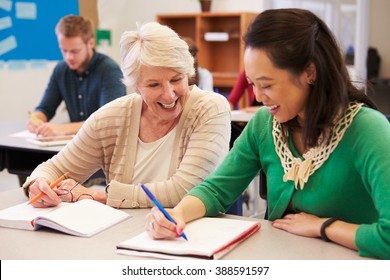 Teacher And Student Sit Together At An Adult Education Class