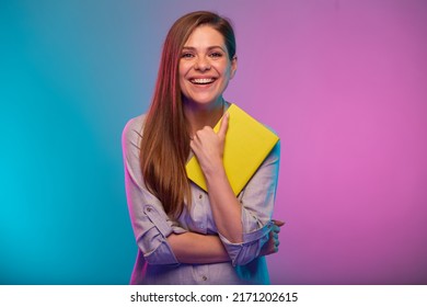 Teacher Or Student Woman Holding Book, Portrait With Neon Lights Colors Effect. Female Model Isolated On Neon Background