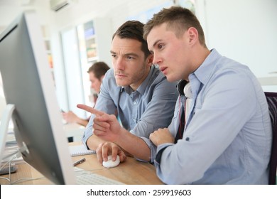 Teacher With Student Working On Desktop