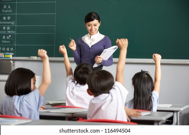 Teacher With Students In Chinese School Classroom