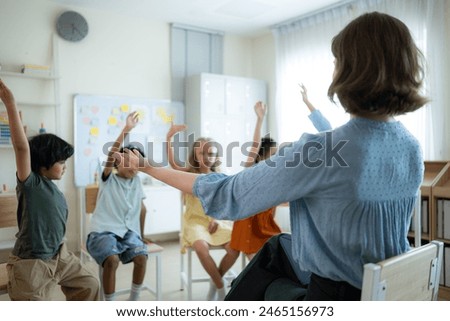 Teacher and students, Learn and study in a classroom of school where youngsters sit and listen attentively.