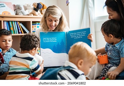 Teacher And Students Reading A Christmas Story Together