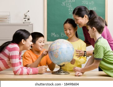 Lehrer und Schüler, die den Globus in der Geografie-Klasse betrachten