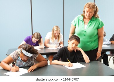 Teacher Supervising Students Who Are Taking A Standardized Achievement Test.