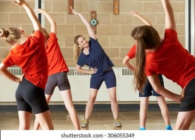 Teacher Taking Exercise Class In School Gym