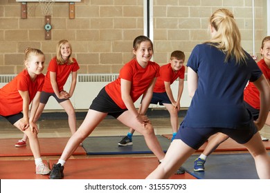 Teacher Taking Exercise Class In School Gym