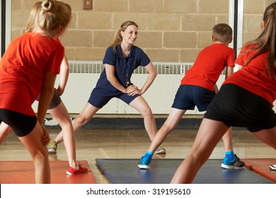 Teacher Taking Exercise Class In School Gym