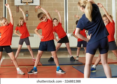 Teacher Taking Exercise Class In School Gym