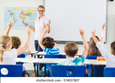 Teacher Teaching Kids In Classroom At School