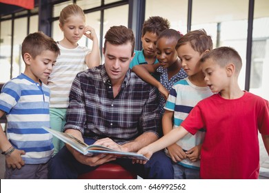 Teacher Teaching Schoolkids In Library At School