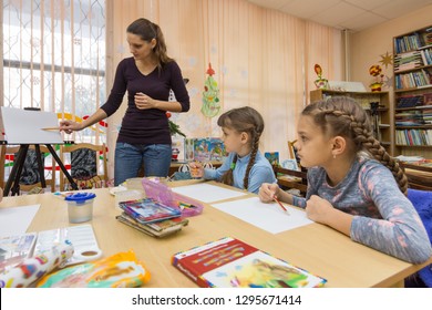 The teacher tells the students how to draw - Shutterstock ID 1295671414
