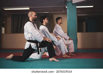 
A Teacher And Two Taekwondo Students Stretching In A Gym.
Martial Art Concept.