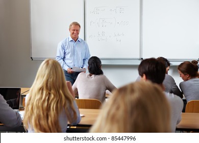 Teacher At University In Front Of A Chalkboard