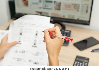 Teacher Use A Red Pen Check Example Sheet And Examination  Equipment On The Wood Table And Use Desktop Computer Working In The Background