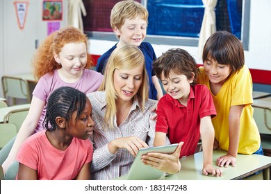 Teacher using digital media on tablet PC in elementary school class - Shutterstock ID 183147248