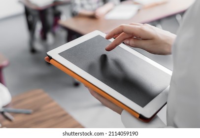 teacher using digital tablet with blank screen - Shutterstock ID 2114059190