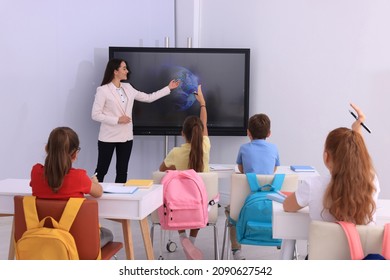 Teacher using interactive board in classroom during lesson - Powered by Shutterstock