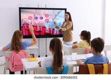 Teacher Using Interactive Board In Classroom During Lesson