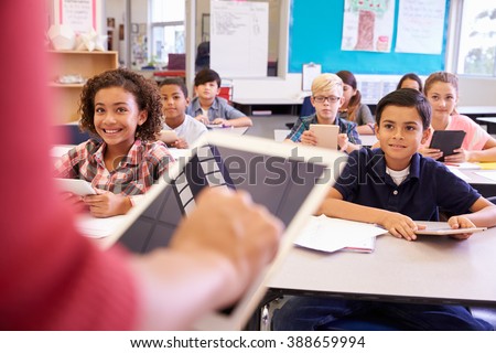 Teacher using tablet computer in elementary school lesson