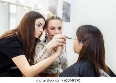 Teacher Visagiste With Her Student Girl Applying Makeup At Master Class In Beauty School