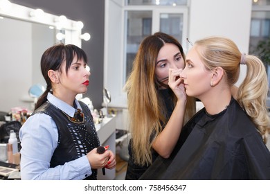 Teacher Visagiste With Her Student Girl Applying Makeup On The Eyes At Master Class In Beauty School