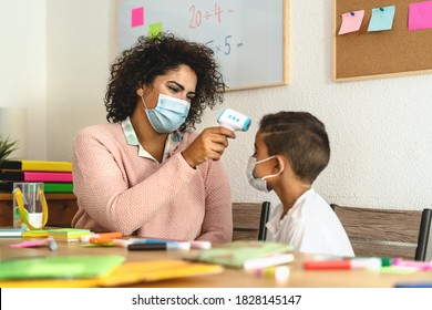 Teacher woman checkup  temperature on child in classroom during corona virus pandemic - Healthcare medical and education concept - Powered by Shutterstock