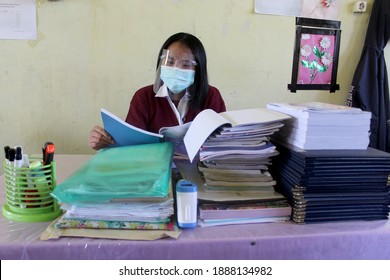 A Teacher Is Working In The Office During COVID-19 Pandemic With Mask And Face Shield On. Teaching With Health Protocol.