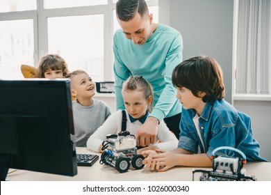 Teacher Working With Teen Students On Diy Robot On Stem Education Class