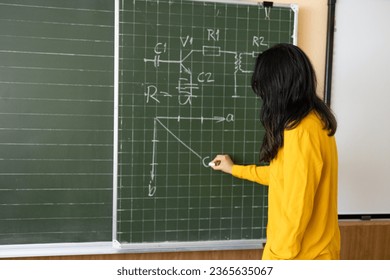 Teacher write on the blackboard and explain a lesson.  - Powered by Shutterstock