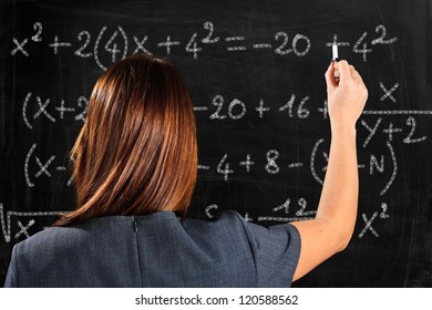 Teacher Writing Formulas On A Blackboard