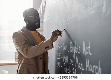 Teacher writing information on blackboard - Powered by Shutterstock