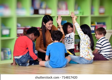 Teachers and children having fun on learning in an international school library.teacher ,education, kid and primary school concept .