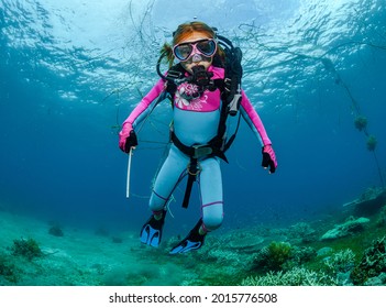 Teaching A Child To Dive Underwater In Scuba Gear