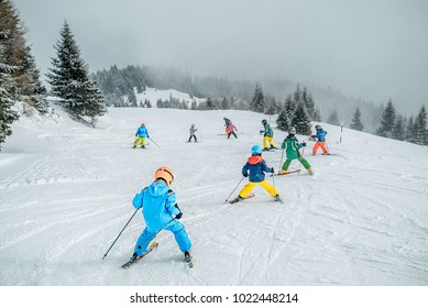 Teaching Children Skiing. Child Skiing In The Mountains With Instructor. Children Learning Ski On The Slope. Mountain Ski Resort. Winter Sport.  Kid In Ski School. Winter Sport For Kids. Making Turns